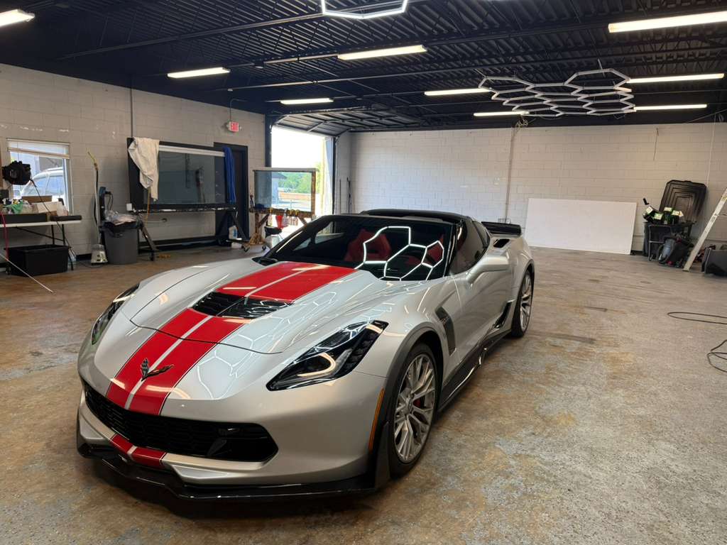 Silver Corvette with red racing stripes after window tinting at TINT WORXZ